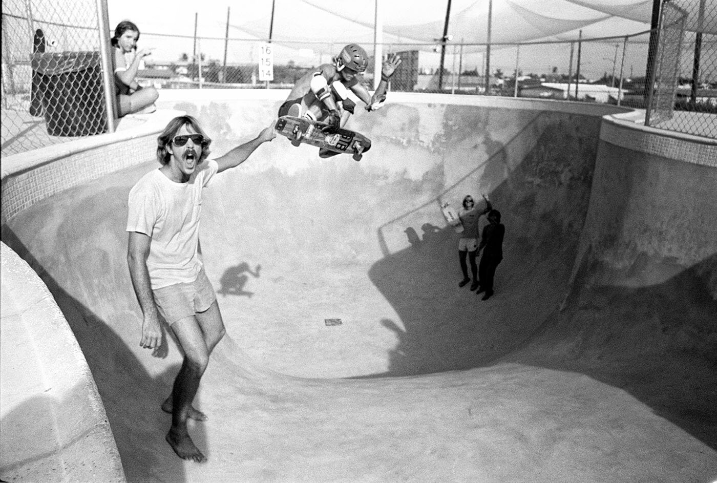 Dan Murray, aerial in the Monster Hole, with Frank Nasworthy in the foreground, Cadillac Wheels Skateboard Concourse, Lighthouse Point, Florida, 1978. _Craig Snyder